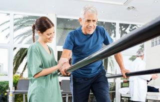 caregiver helping the patient on his workout