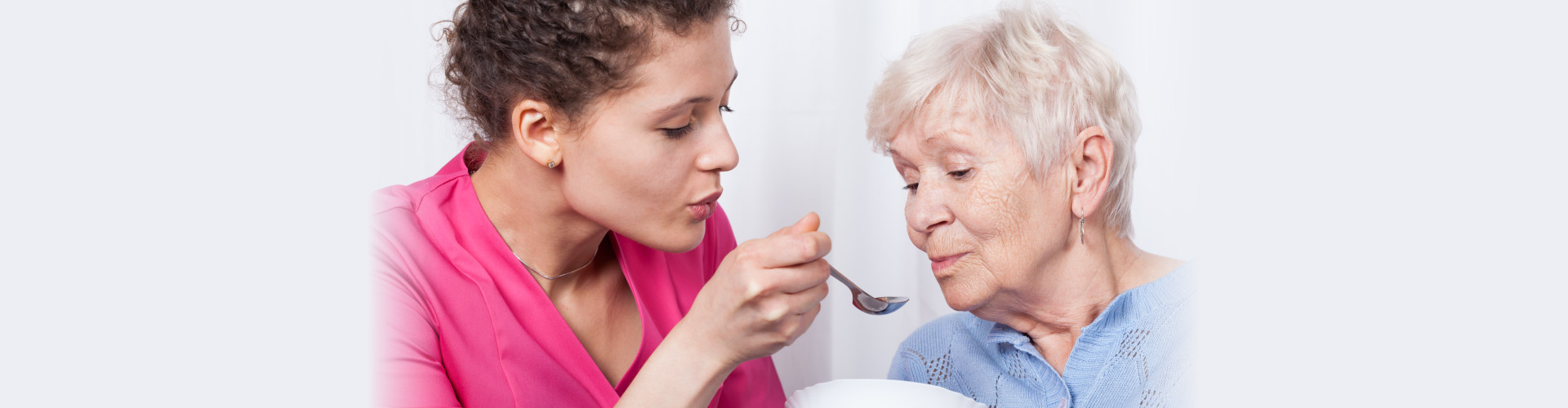 caregiver feeding a senior