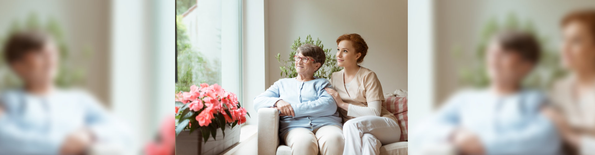 senior and caregiver sitting on couch looking outside